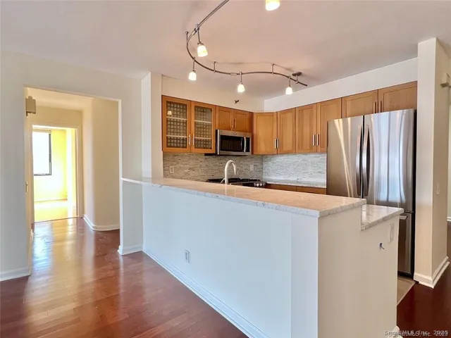a kitchen with stainless steel appliances granite countertop a refrigerator sink and cabinets