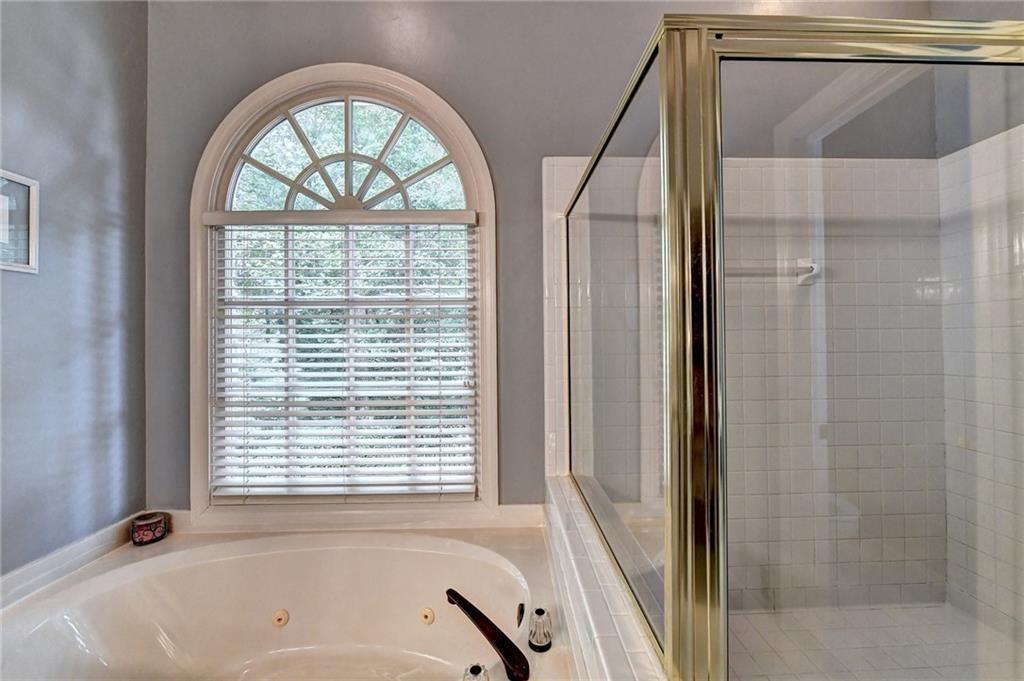 1595 Chadberry Way Lawrenceville, GA 30043 - Photo 11 of 47 a bathroom with a bathtub and a shower