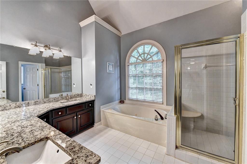 1595 Chadberry Way Lawrenceville, GA 30043 - Photo 15 of 47 a spacious bathroom with a granite countertop tub mirror and double vanity