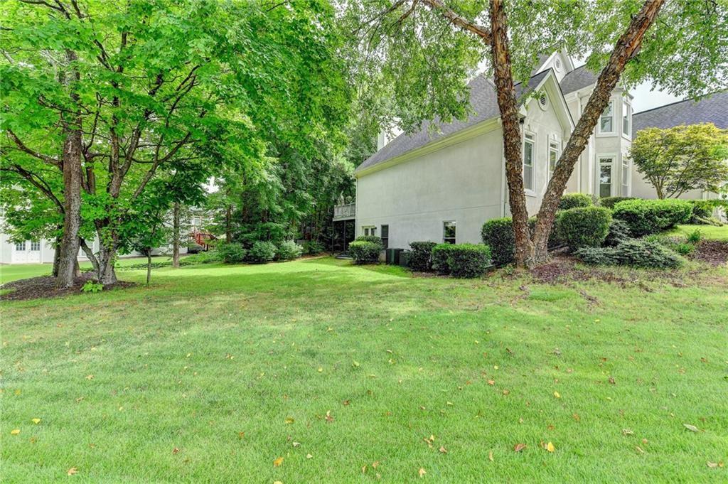 1595 Chadberry Way Lawrenceville, GA 30043 - Photo 23 of 47 a backyard of a house with plants and large tree
