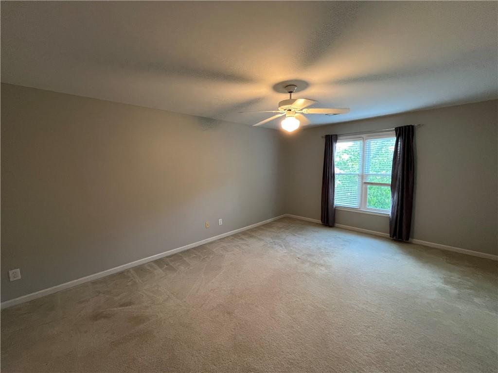 1595 Chadberry Way Lawrenceville, GA 30043 - Photo 42 of 47 an empty room with windows and chandelier fan