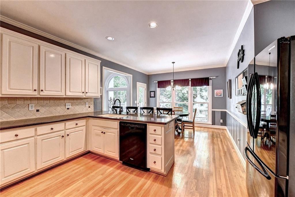 1595 Chadberry Way Lawrenceville, GA 30043 - Photo 8 of 47 a kitchen with stainless steel appliances granite countertop hardwood floor sink stove dining table and chairs