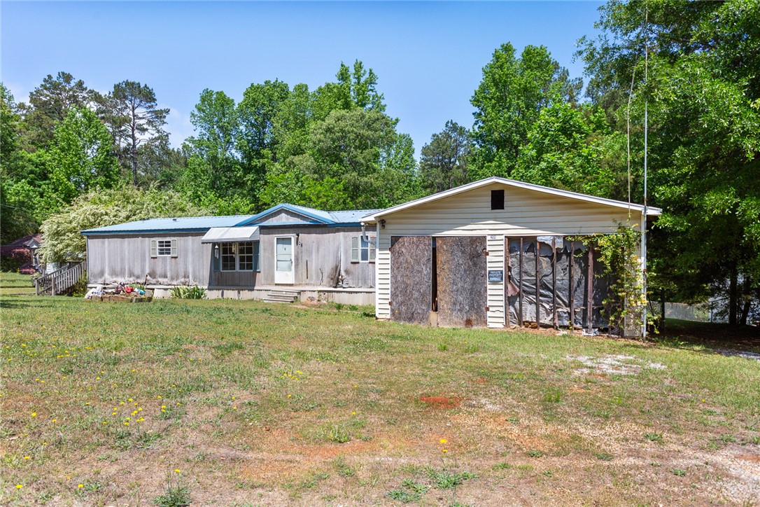 This property features a structure with wood siding and a detached garage, offering a serene, private setting.