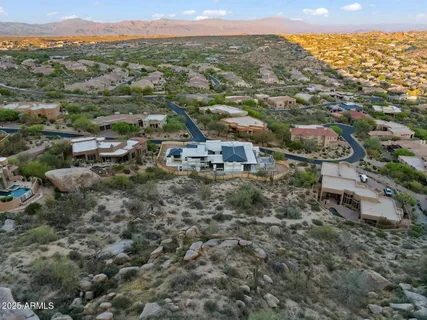 an aerial view of residential houses with outdoor space and trees