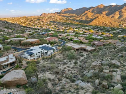 an aerial view of residential houses with outdoor space and trees