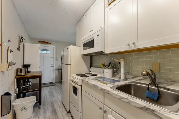 a kitchen with a stove and a wooden floor