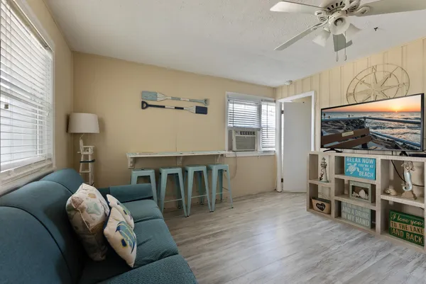 a living room with furniture a flat screen tv and wooden floor