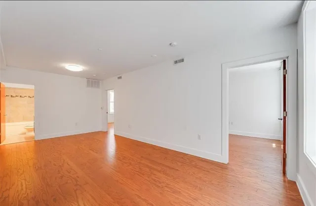 a view of an empty room with wooden floor
