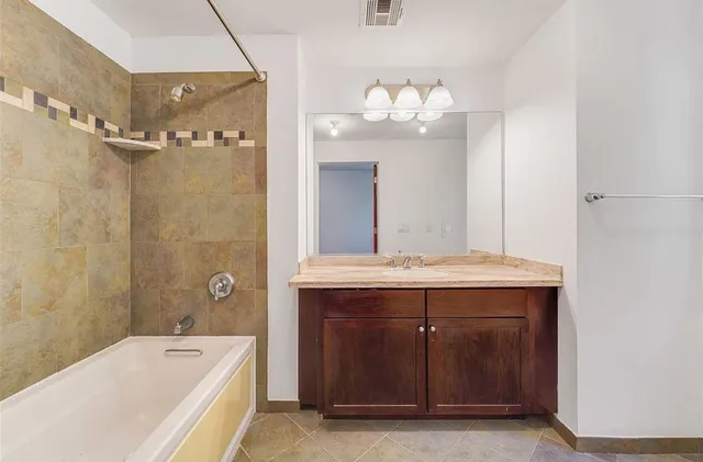 a bathroom with a tub a sink and mirror