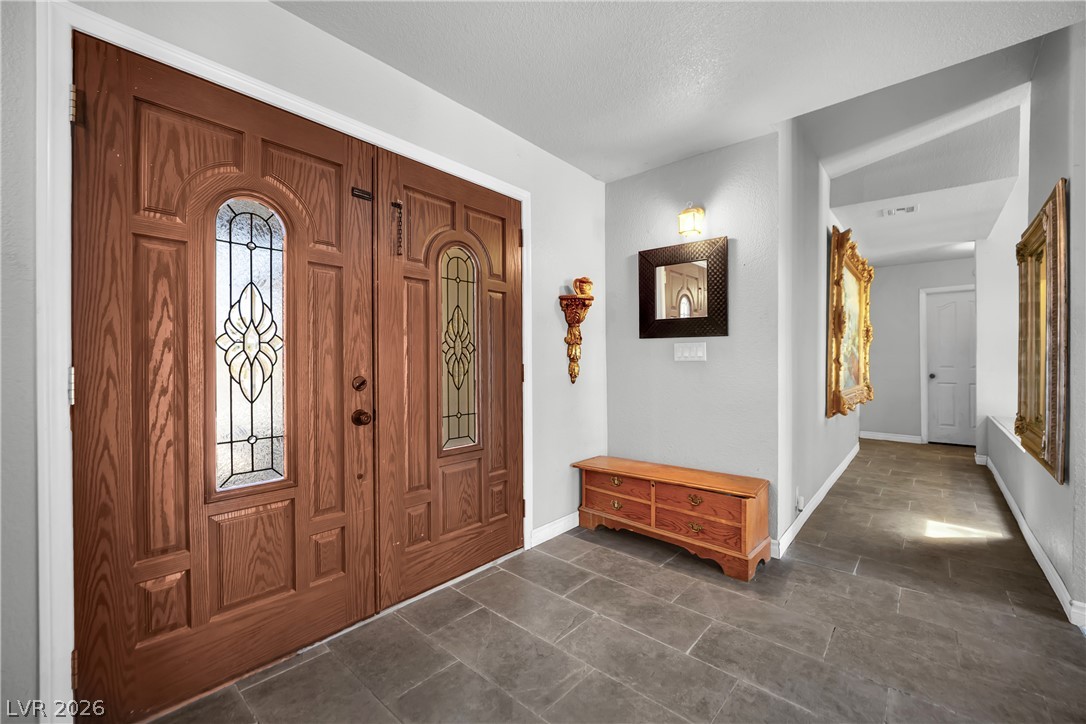 420 North Racetrack Road Henderson, NV 89015 - Photo 37 of 52 Elegant wooden entry doors with ornate glass panels open to a tiled foyer.
