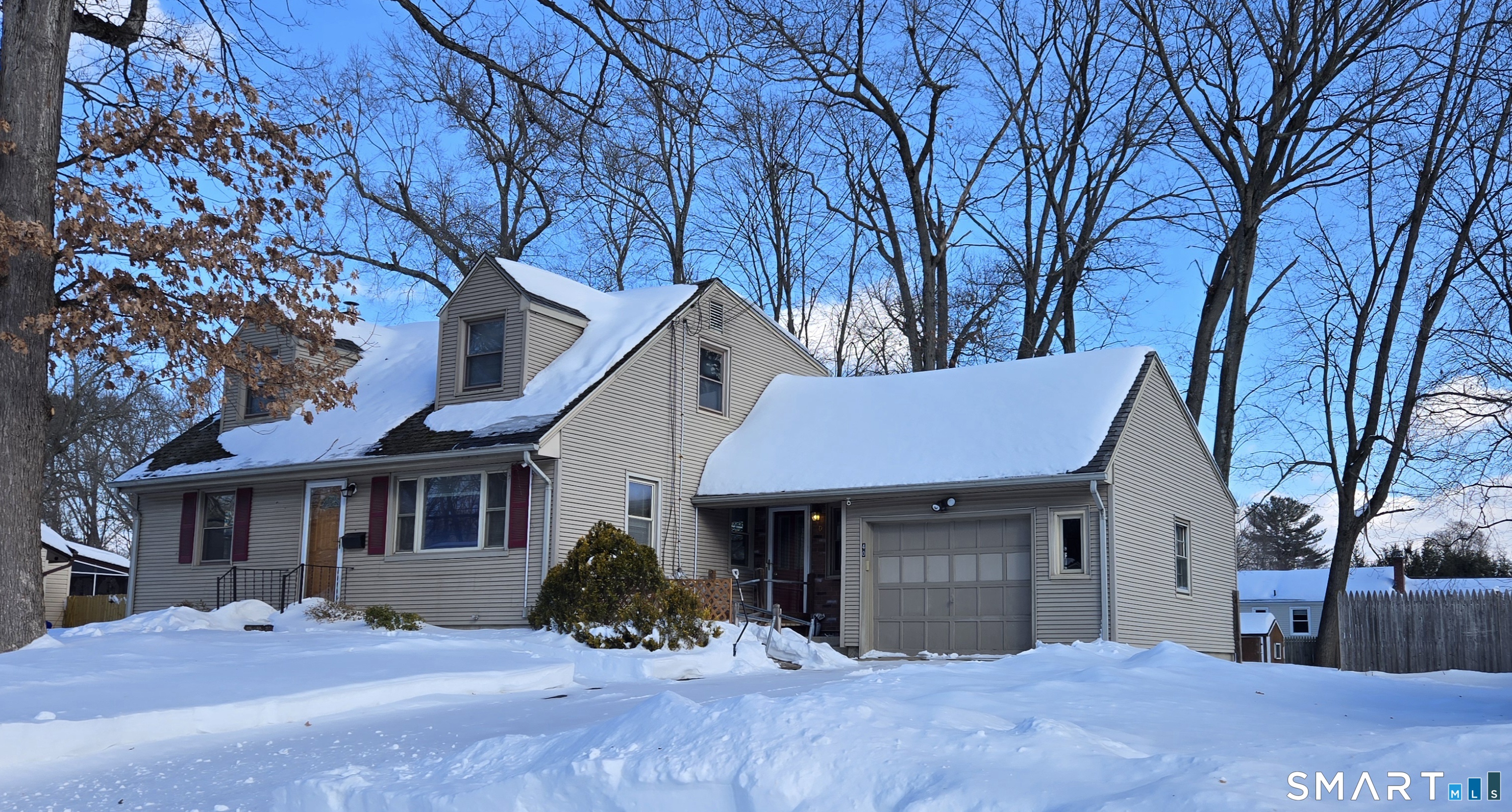 a view of a white house with a large tree