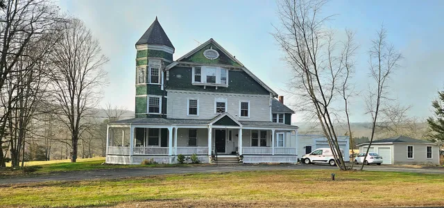 a front view of residential houses with yard and trees