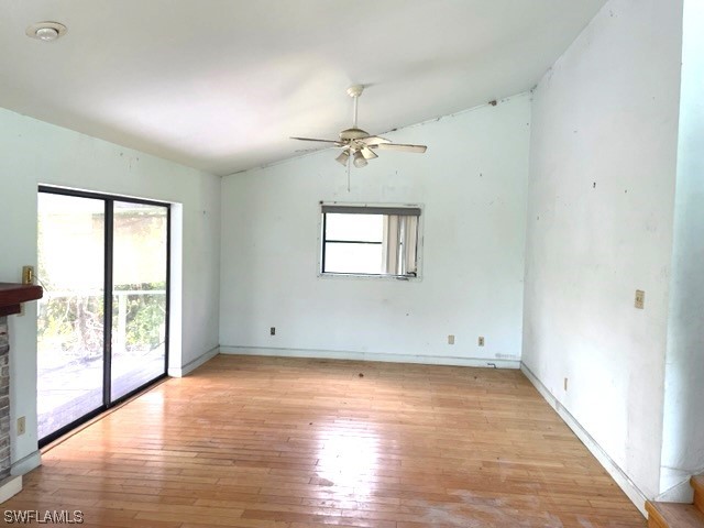 6670 Sun Rise Lane Bokeelia, FL 33922 - Photo 5 of 13 an empty room with wooden floor chandelier fan and windows