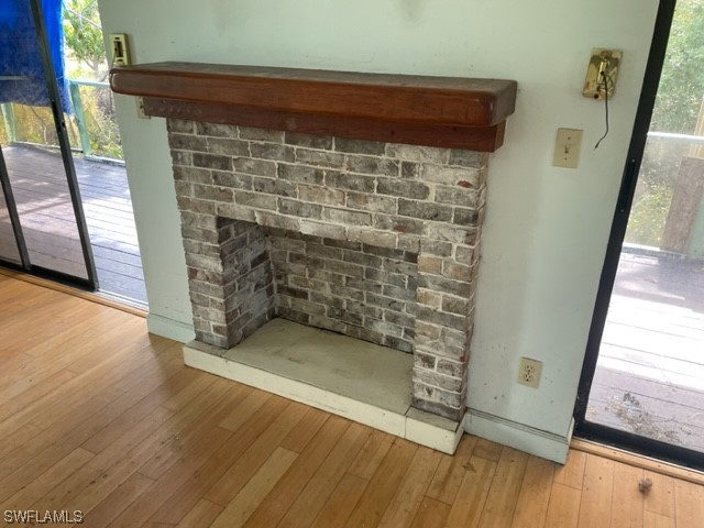 6670 Sun Rise Lane Bokeelia, FL 33922 - Photo 6 of 13 a bathroom with a wooden floor and a fireplace