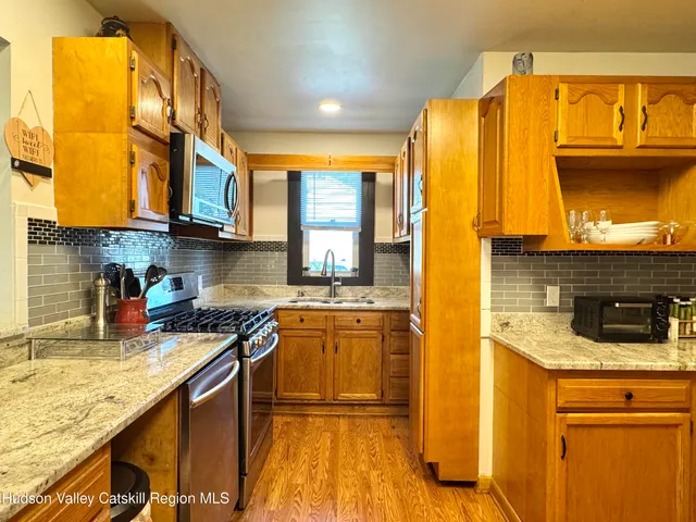 a kitchen with stainless steel appliances granite countertop a stove a sink and a microwave
