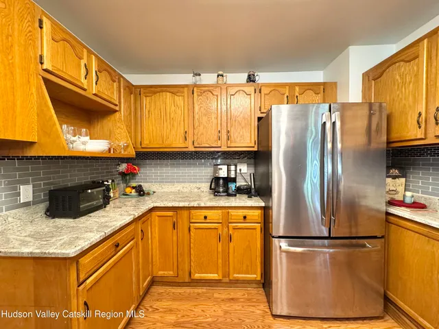 a kitchen with stainless steel appliances granite countertop a refrigerator a stove a sink and a microwave