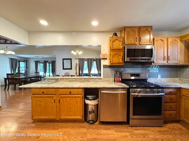a kitchen with stainless steel appliances granite countertop a stove top oven a sink dishwasher and microwave oven on the granite countertops