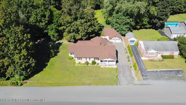 an aerial view of a house with a yard basket ball court and outdoor seating
