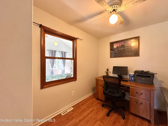 a view of a workspace with furniture and a window