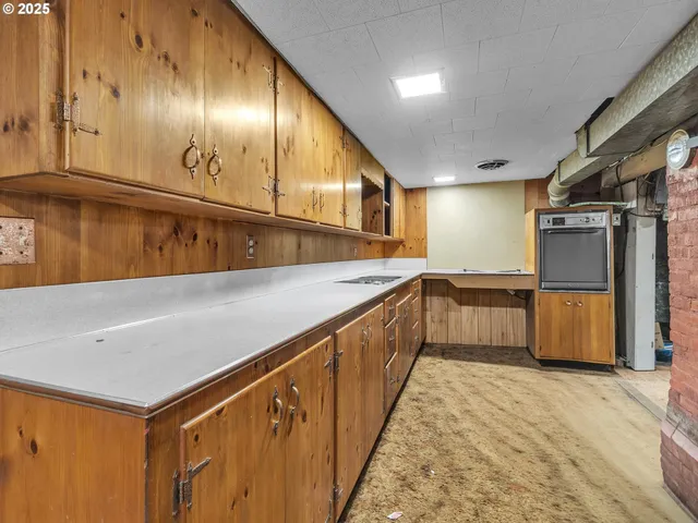 a large kitchen with granite countertop a sink a stove and a refrigerator