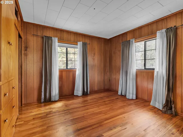 an empty room with wooden floor and a window