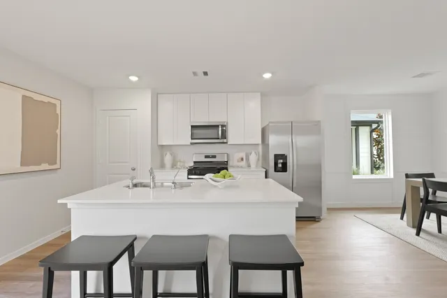 a kitchen with a dining table chairs and refrigerator