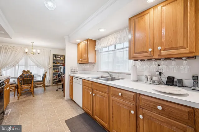 a kitchen with granite countertop wooden cabinets a sink a window and stainless steel appliances