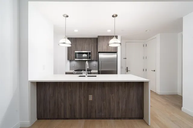 a kitchen with kitchen island a sink stainless steel appliances and cabinets