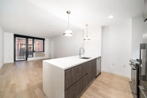 a view of a kitchen with a sink wooden floor and a chandelier