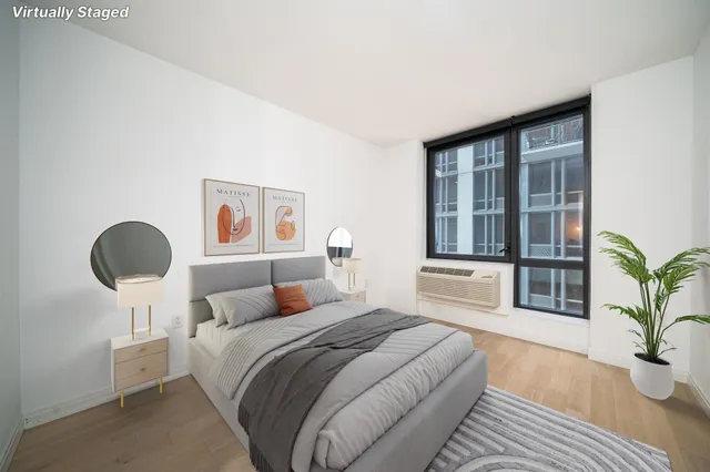 a bedroom with a large bed and a potted plant