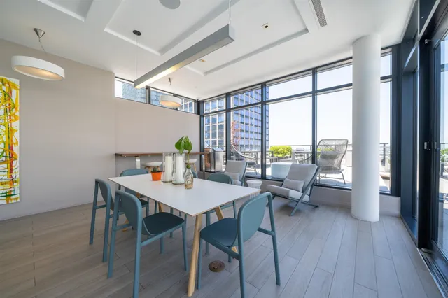 a living room with furniture large windows and flat screen tv