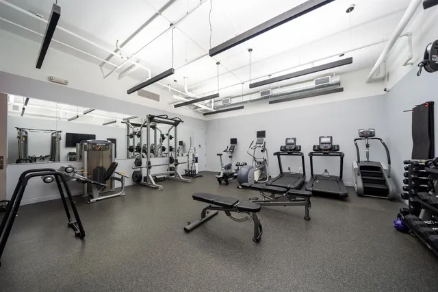 a living room with furniture and a dining table with wooden floor