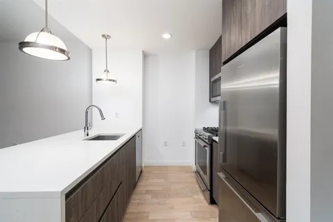 a kitchen with stainless steel appliances granite countertop a refrigerator and a sink
