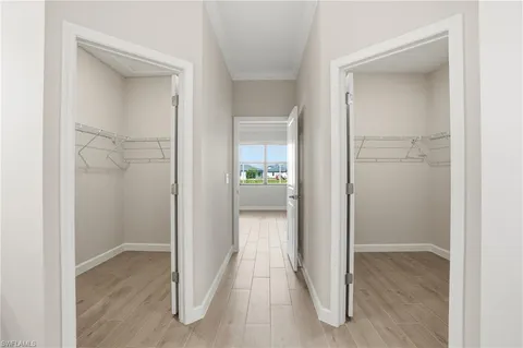 a view of a hallway with wooden floor and a living room