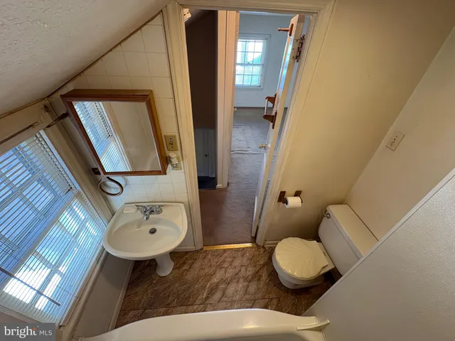 a bathroom with a toilet sink and mirror