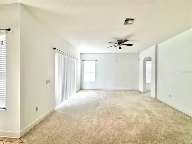 an empty room with a window and a ceiling fan