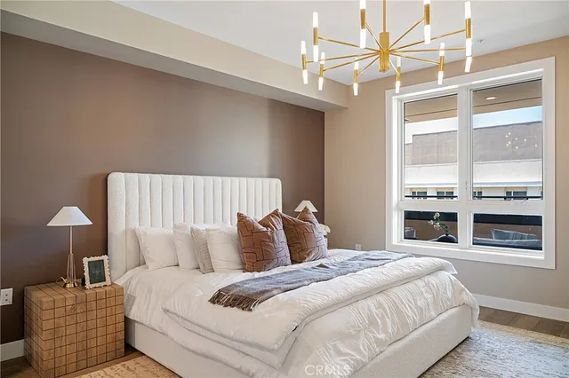 a bedroom with a large bed and a chandelier