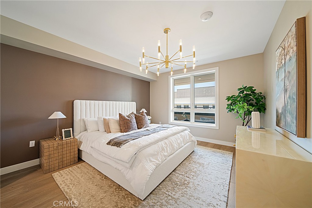 39 South Los Robles Avenue, Unit 6010 Pasadena, CA 91101 - Photo 22 of 38 a bedroom with a large bed and a chandelier