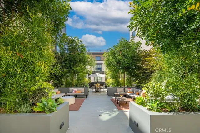 a view of a patio with couches table and chairs and potted plants