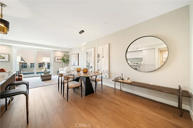 a open kitchen with stainless steel appliances granite countertop a stove top oven a sink dishwasher a dining table and chairs with wooden floor