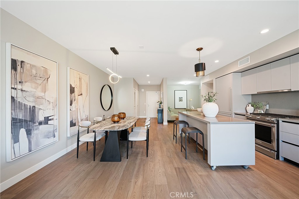 39 South Los Robles Avenue, Unit 6010 Pasadena, CA 91101 - Photo 6 of 38 a open kitchen with stainless steel appliances granite countertop a stove top oven a sink dishwasher a dining table and chairs with wooden floor