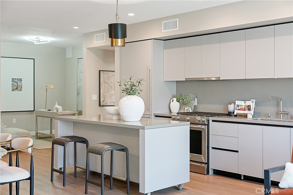 39 South Los Robles Avenue, Unit 6010 Pasadena, CA 91101 - Photo 7 of 38 a kitchen with stainless steel appliances kitchen island a table chairs in it and white cabinets