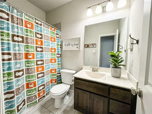 a bathroom with a sink a toilet and shower curtain