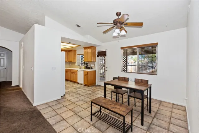 a living room with furniture a dining table and a refrigerator