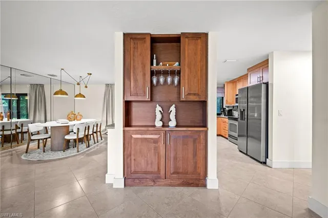 a kitchen with stainless steel appliances kitchen island granite countertop a refrigerator and a sink