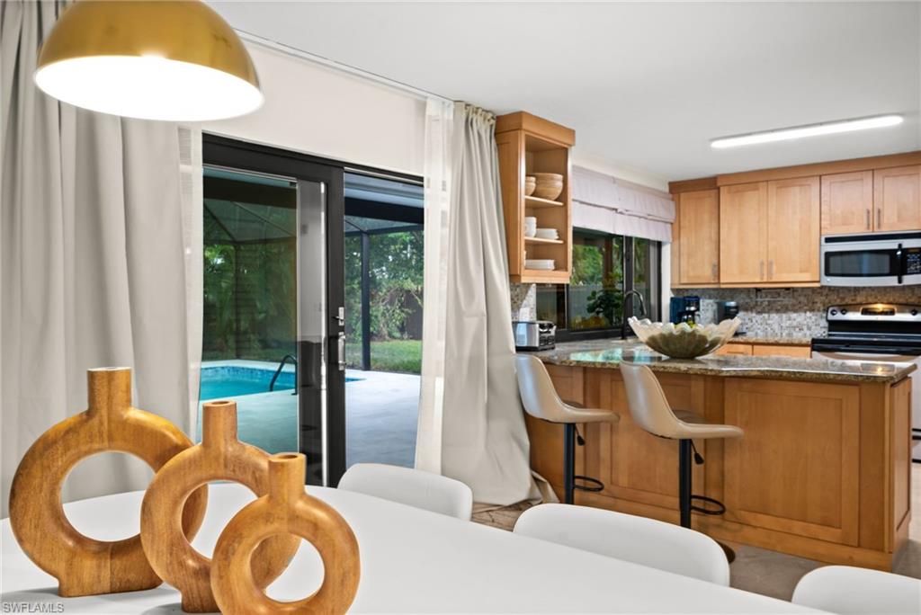 472 Palm River Boulevard Naples, FL 34110 - Photo 2 of 50 a kitchen with a refrigerator and a sink