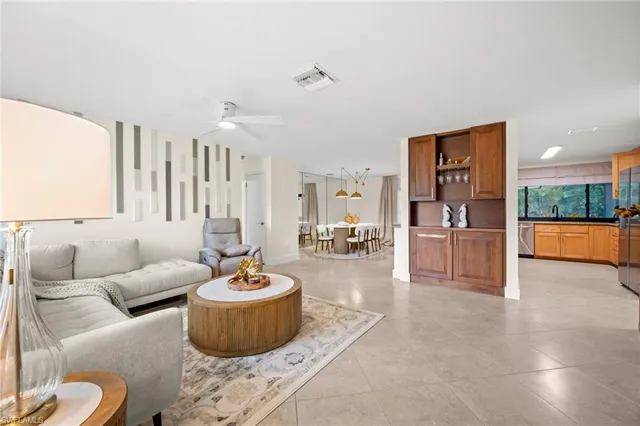 a living room with furniture and a view of kitchen