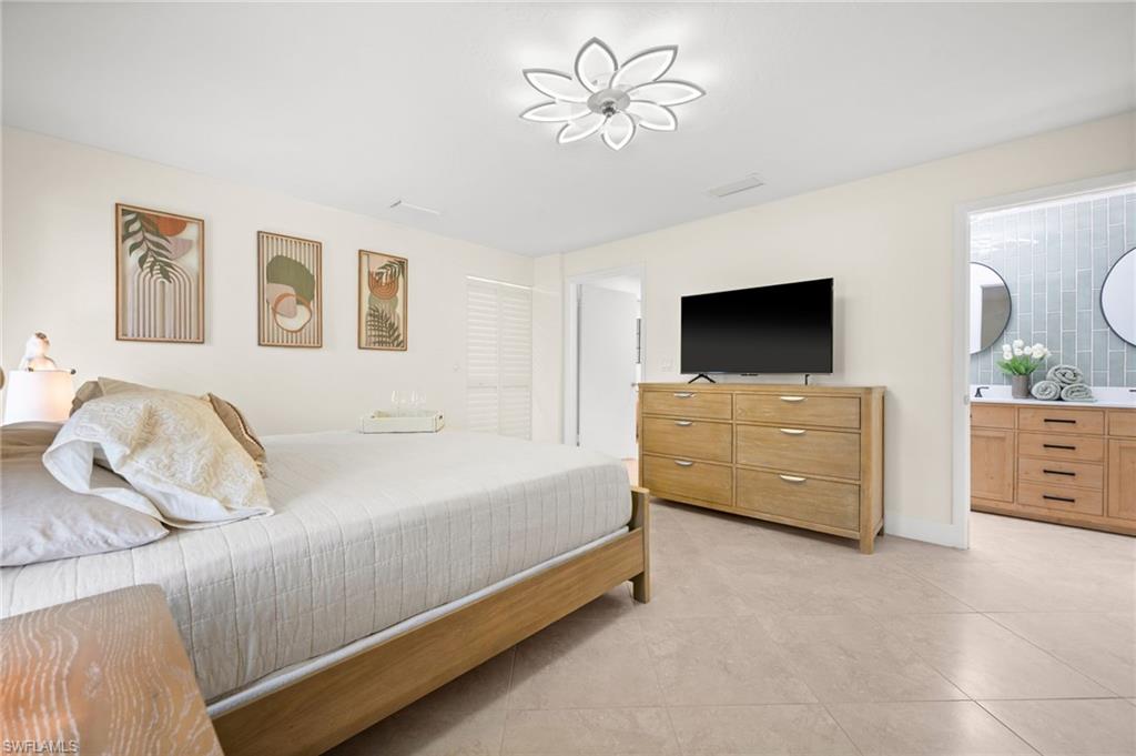 472 Palm River Boulevard Naples, FL 34110 - Photo 34 of 50 a bedroom with a bed and a flat screen tv