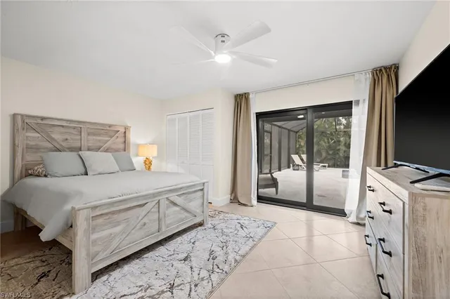 a bedroom with a large bed and a flat tv screen on dresser