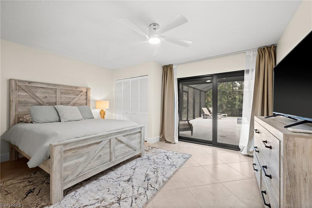 472 Palm River Boulevard Naples, FL 34110 - Photo 38 of 50 a bedroom with a large bed and a flat tv screen on dresser